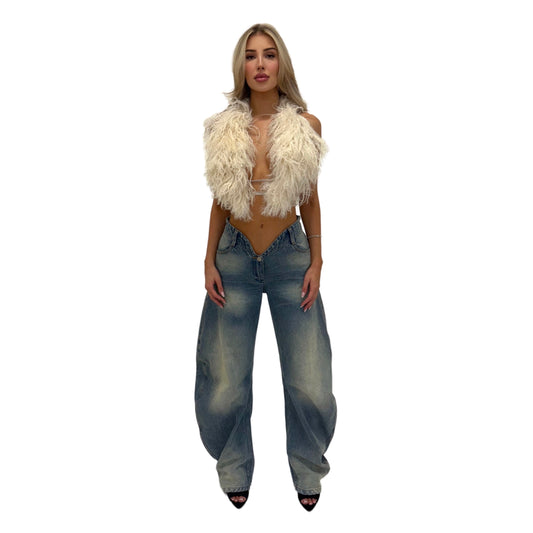 woman wearing a white fur halter top and light wash denim jeans on a white background